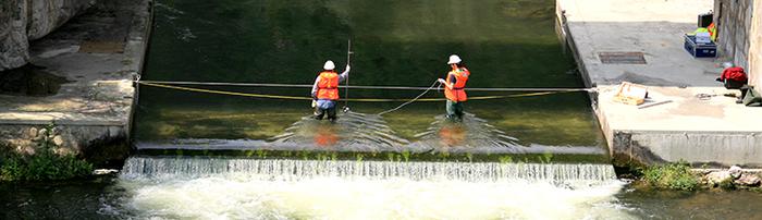 Foto 1. Aforadors mesurant el cabal d'aigua d'un tram de riu. 