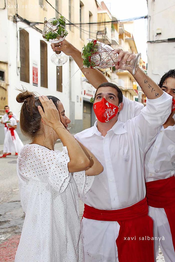 Macip ruixant a la gent del poble durant la Festa de Sant Roc d'Arenys de Mar,