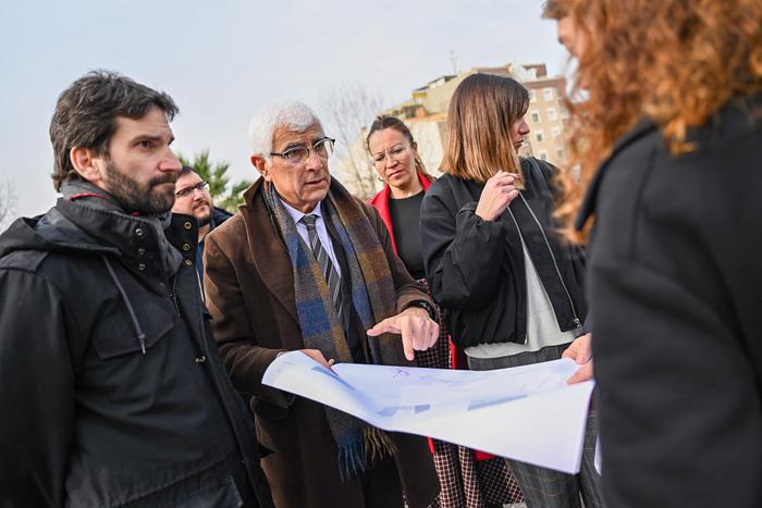 El conseller Balcells sostenint un plànol, d'un dels nous equipaments sanitaris que es construiran al Baix Llobregat, i acompanyat d'autoritats de la comarca.